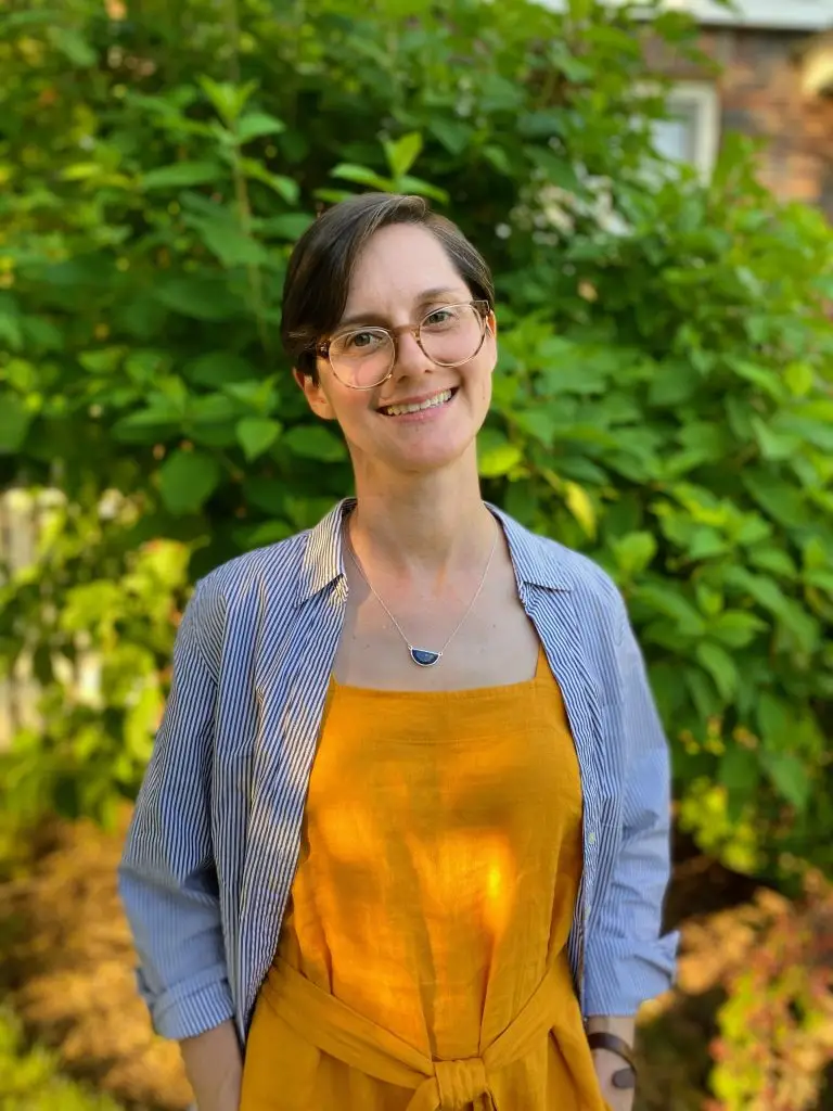 Katie Crank, LCSW, a queer and trans affirming therapist in Bloomfield, NJ, smiling outdoors